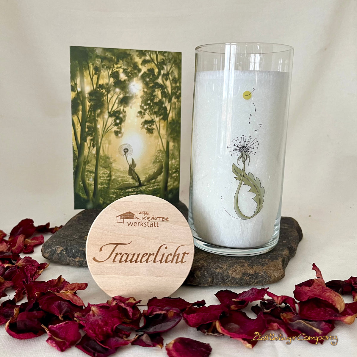 Trauerlicht Pusteblume. Allgäuer Heilkräuterkerze im Glas, mit Beileidskarte, auf der ein Waldmotiv aufgedruckt ist. Glas mit Aufdruck Pusteblume. Gravierter Holzdecke mit Aufschrift Trauerlicht. 