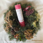 Magie der Weihnacht, Weihnachtskerze aus der Allgäuer Heilkräutermanufaktur, Farbe rot. Stimmungsvoll im Adventskranz posiert.