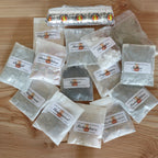 Rauhnächte Räucherset, Einzelansicht des Inhalts:  13 Räucherzutaten, verpackt im Papierbeutel, 1 Rolle Räucherkohle und Sand.